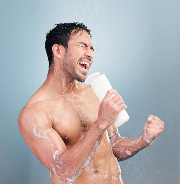 一位健壮的年轻混血男人在蓝色背景的淋浴中唱歌图片下载