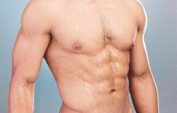 特写孤立的躯干的一个男人淋浴干净，新鲜的水滴下他的身体。一个身材健美的人，湿漉漉的躯干和健美运动员的肌肉，在工作室里展示他健美的腹肌和腹部图片下载