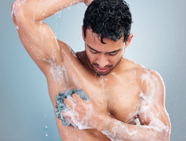 在蓝色背景下淋浴的年轻混血男人图片下载