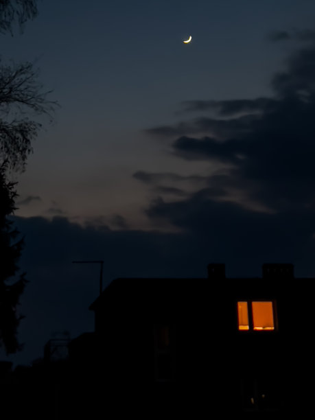 镰刀状的月亮在部分多云的天空中升起图片下载