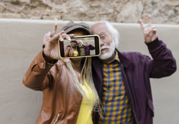 老年夫妇拍照片与智能手机在他们的旅行-退休老人的概念-图片下载