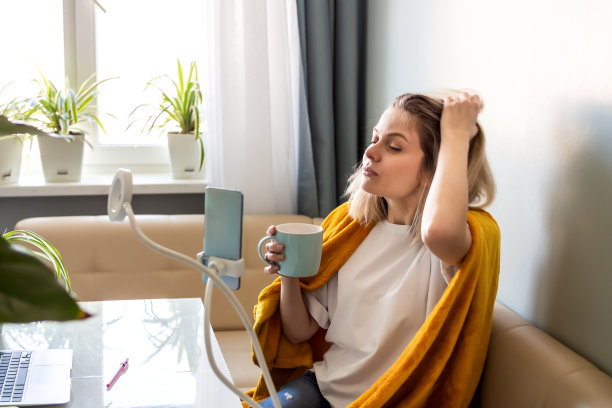 金发女子博主制作照片视频内容的社交媒体与智能手机在三脚架真实的生活方式肖像的人在家里工作图片下载