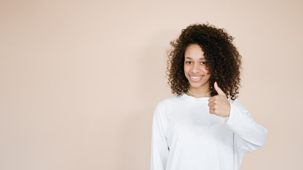 非洲裔美国女孩举手竖起大拇指露齿微笑图片下载