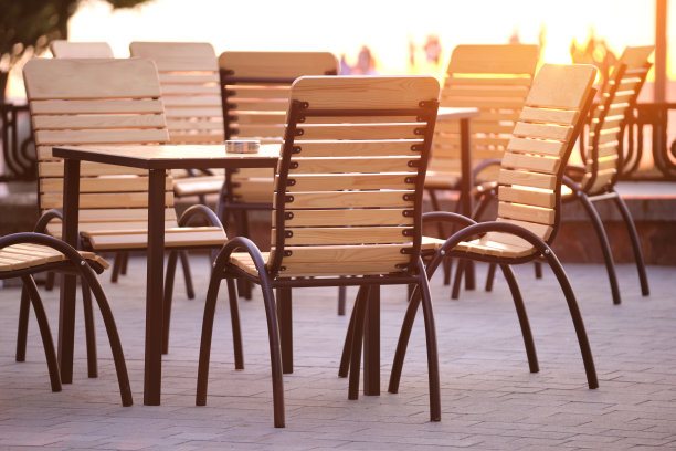 户外咖啡馆椅子和桌子的特写在日落的城市街道图片下载