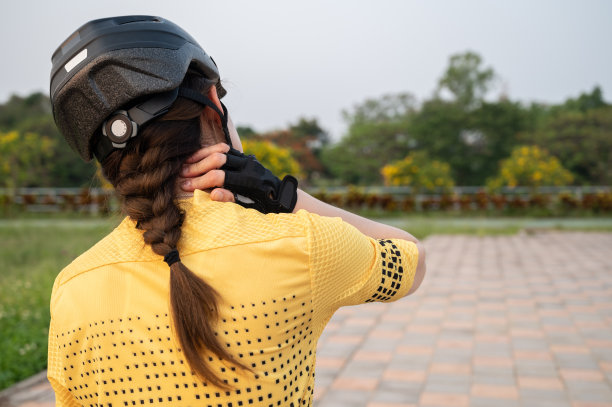 因长时间骑自行车而颈部疼痛的女性骑车者后视图。图片下载
