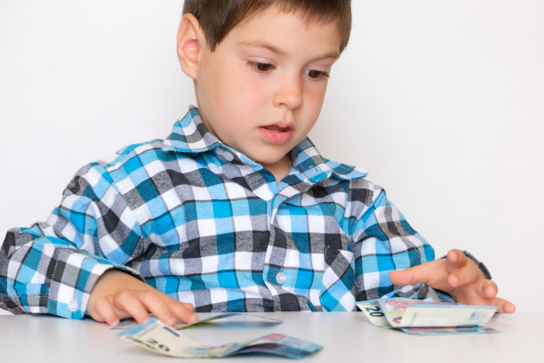一个4岁的男孩在数钱，手里拿着欧元。图片下载
