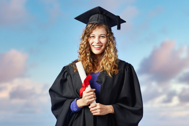 快乐的女学生戴着毕业帽，穿着毕业服，拿着学位证书，看起来骄傲而满足图片下载