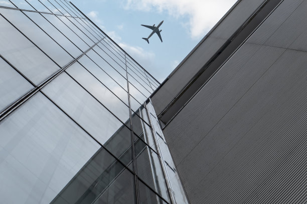 飞机飞过现代建筑图片下载