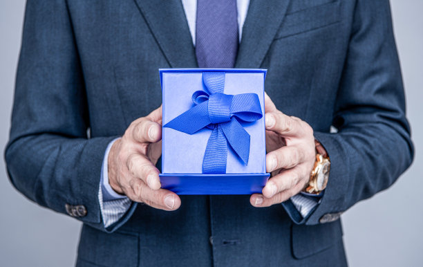包装你完美的礼物。男人手里拿着蓝盒子。生日纪念日。节日的庆祝活动。礼品商店图片下载