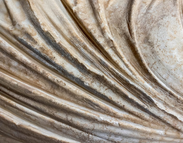 古老的纹理。米色石材，背景宽大。一个穿长袍的雕像，一块大理石布。生锈的白色背景图片下载