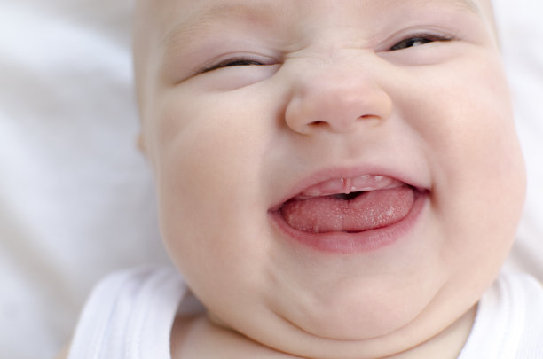 微笑婴儿嘴特写。婴儿主要的生齿。儿童保健和抚慰概念。图片下载