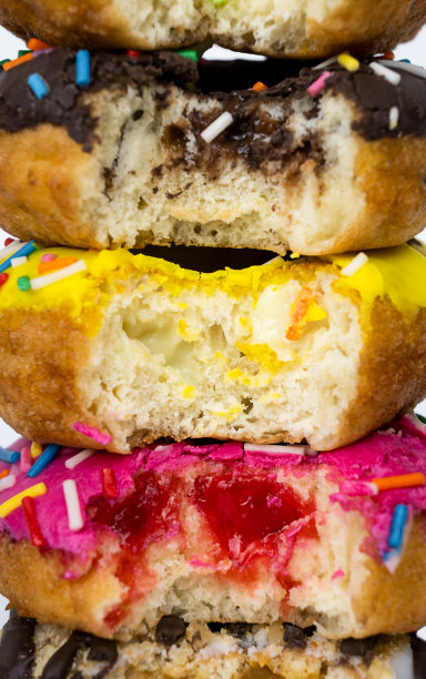 甜甜圈的微距照片。巧克力，奶油，香蕉和草莓的甜甜圈。食品的背景图片下载