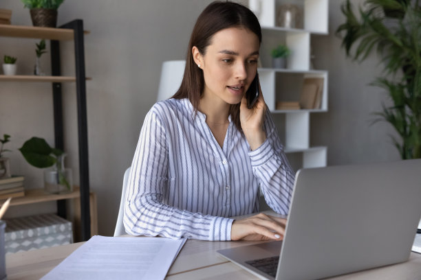 严肃的年轻员工打电话，使用应用电脑图片下载
