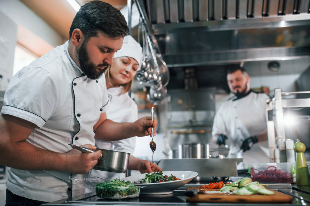 三个人在制作纯素沙拉，专业厨师在厨房准备食物图片下载