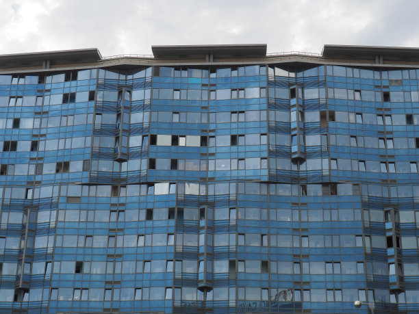 天空和建筑的玻璃立面。蓝天白云在玻璃墙上的倒影。城市摩天大楼。现代玻璃建筑和建筑。生态的概念图片下载