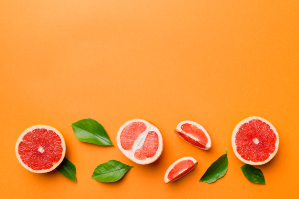 鲜果柚子与多汁柚子切片彩色背景。前视图。副本的空间。创造性的夏天的概念。一半柑橘在最小的平铺复制空间图片下载