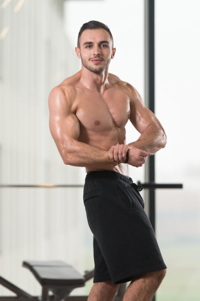 严肃的健美运动员站在健身房图片下载