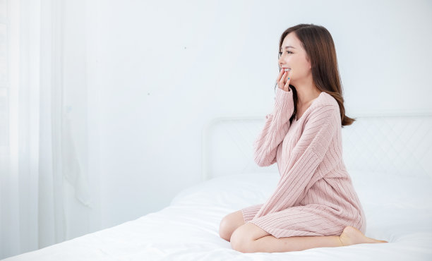 在冬季卧室放松的亚洲美丽女性肖像。性感的美容女孩拥有健康的妆容面部护理完美的光泽皮肤。微笑快乐的Hygge亚洲韩国女孩隔离白色背景。图片下载