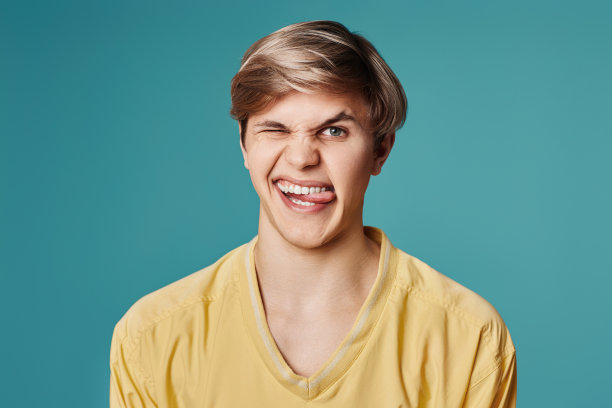 一个在深灰色背景上做鬼脸的帅哥图片下载