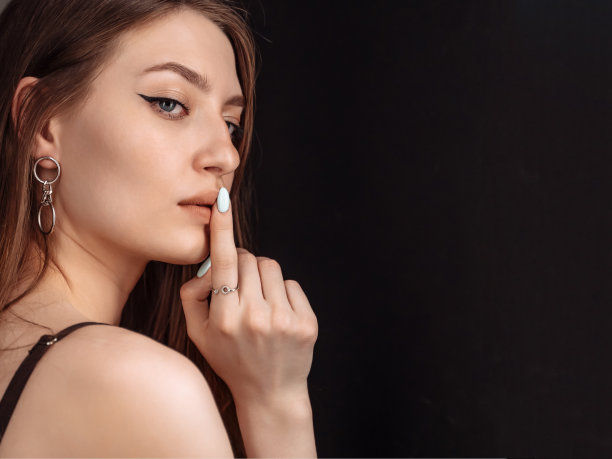 美女在一旁神秘地看着，有耐人寻味的样子，要求安静，为你的广告留白黑色背景图片下载