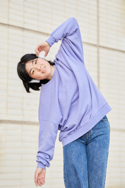 一个年轻的亚洲女孩听音乐的垂直照片。图片下载