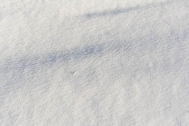 白色不均匀的雪纹理与浮雕的阴影。抽象背景与积雪的表面在春天的时间。图片下载