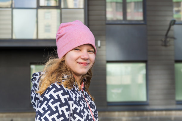 快乐的女孩在新住宅楼的背景下图片下载