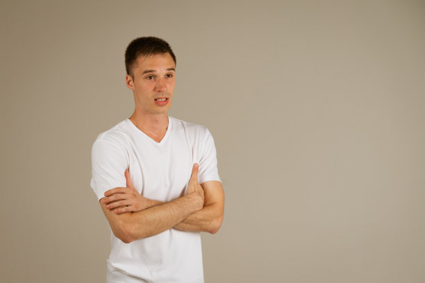 一个穿着白色t恤的男人在背景上打着手势图片下载