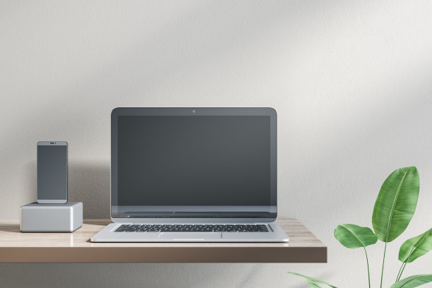 在设计师办公室桌面上的空笔记本电脑和手机的特写。装饰植物和混凝土墙背景。模拟，广告，技术，产品评论和网络研讨会概念。3 d渲染。图片下载