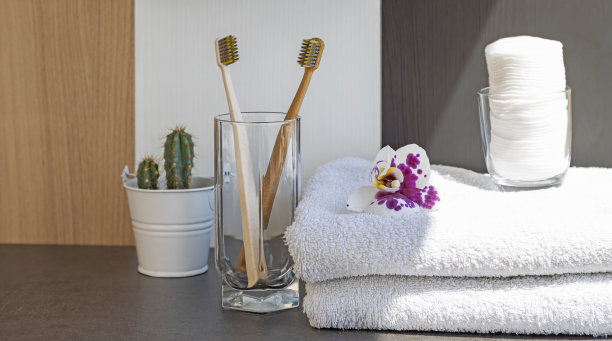 浴室内部，用于口腔卫生的刷子和灰色背景的棉毛巾。图片下载