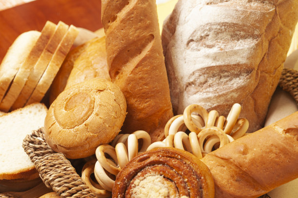 烹饪背景与面包，小圆面包，干燥的百吉饼，小麦耳朵在柳条篮子，俯视图。图片下载