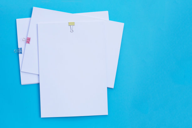 白色纸夹蓝色背景。图片下载