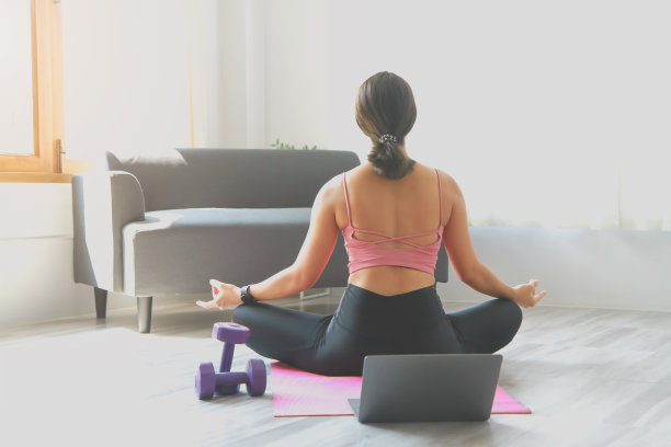 下班后女子在家通过在线课程练习瑜伽。缓解压力、放松肌肉、呼吸练习、锻炼、冥想。图片下载