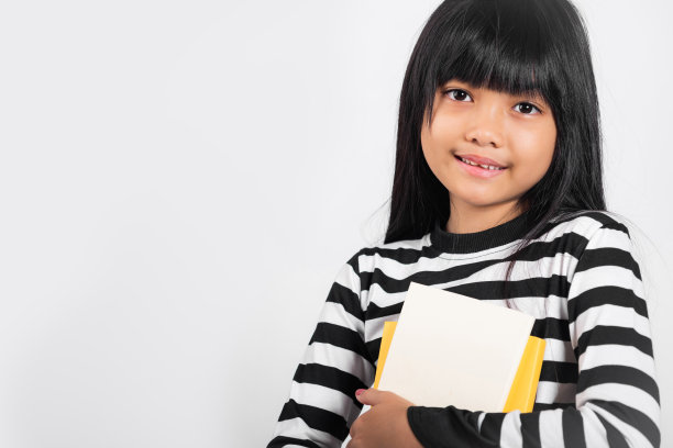 10岁的亚洲小孩拿着书去上学图片下载