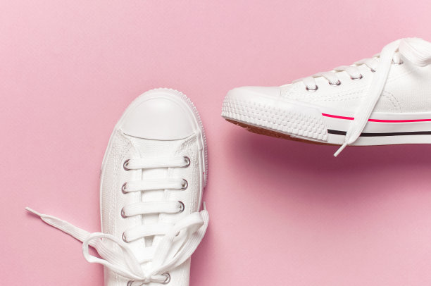 白色女性时尚运动鞋在粉红色的背景。平面布局，俯视图，拷贝空间。女性的鞋子。时尚的白色运动鞋。时尚博客或杂志概念。简约的鞋背景，运动鞋图片下载