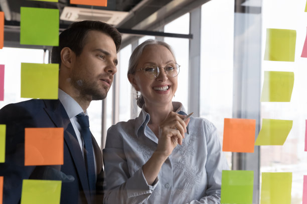 积极不同年龄的办公室同事在贴纸上工作图片下载