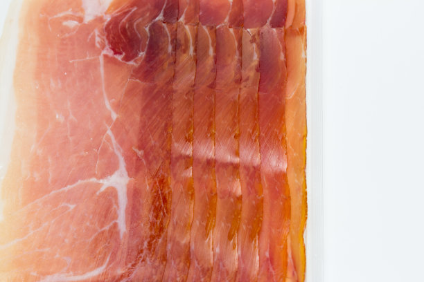 起泡包装或包装的塞拉诺火腿片在白色的背景图片下载