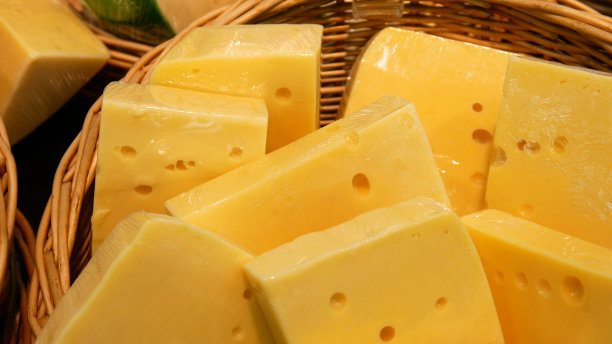 许多美丽的包装奶酪片的特写在一个柳条篮子图片下载