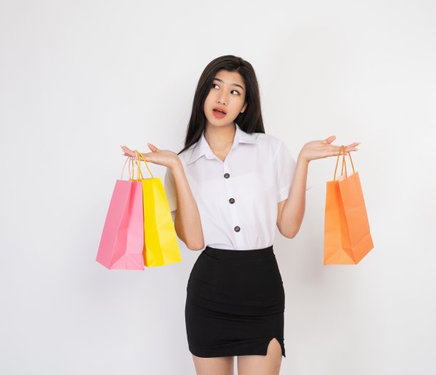 摄影工作室拍摄的时刻和表情的一个年轻的亚洲女士与五颜六色的购物袋图片下载