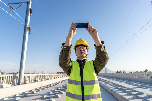 一名亚洲男性工程师在尚未完工的高速公路上用手机拍照图片下载
