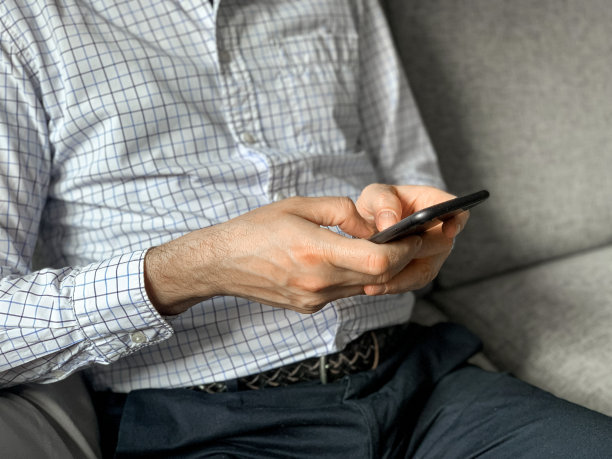 中年男子早上上班前坐在家里的沙发上查看新闻图片下载