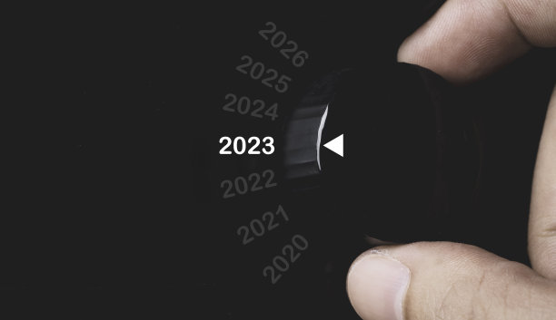 手旋转黑色旋钮，选择2023年，准备圣诞快乐，新年快乐的概念。图片下载