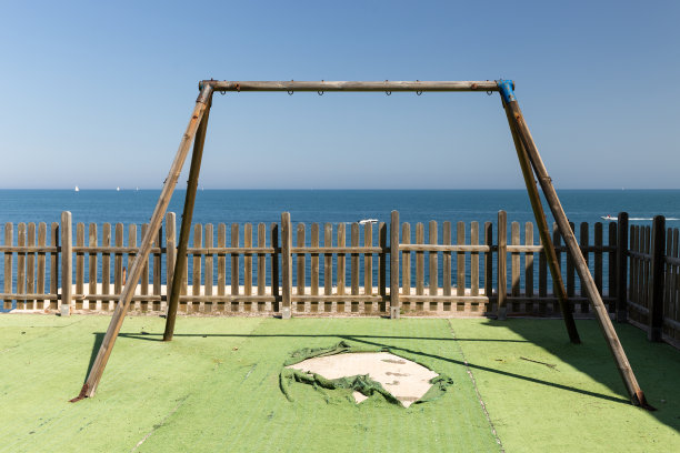 秋千结构上破碎的人造草与木栅栏图片下载