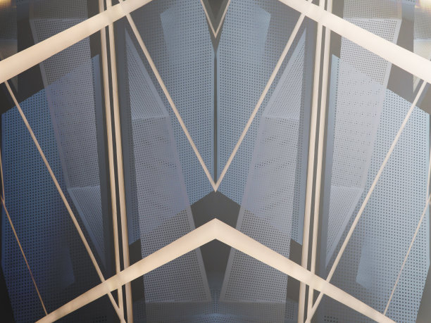 暮色中办公楼框架和装饰穿孔墙板的拼贴照片。现代建筑中的金属。网格结构相互透视。建筑表面。图片下载