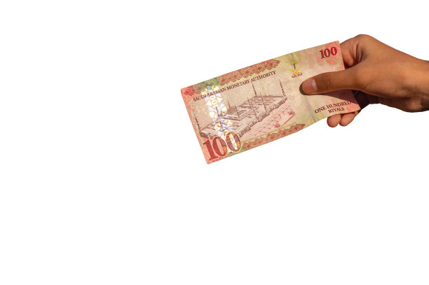 亚洲儿童手里拿着100里亚尔，沙特阿拉伯的货币，概念慈善，给予，开斋节穆巴拉克图片下载