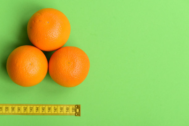 用黄色卷尺附近的橙子做成的图案图片下载