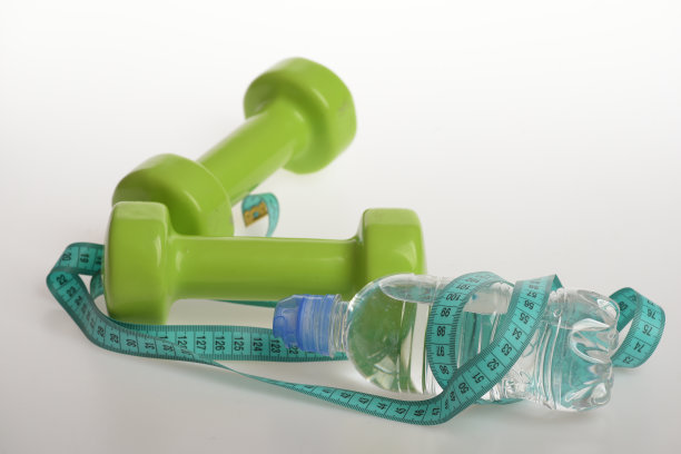 水瓶用青色卷尺绑在绿色哑铃上图片下载
