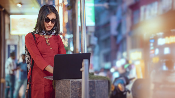 年轻的女商人在忙碌中使用笔记本电脑。图片下载