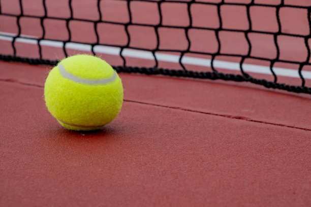 红色硬地网球场的网球。图片下载