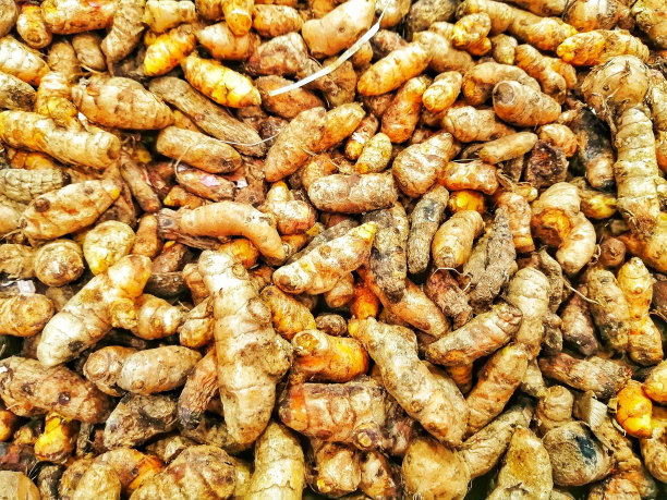 市场上的一堆姜黄。模糊的顶部图像。图片下载